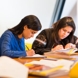 Studenten doen Nederlandse schrijfoefeningen in les